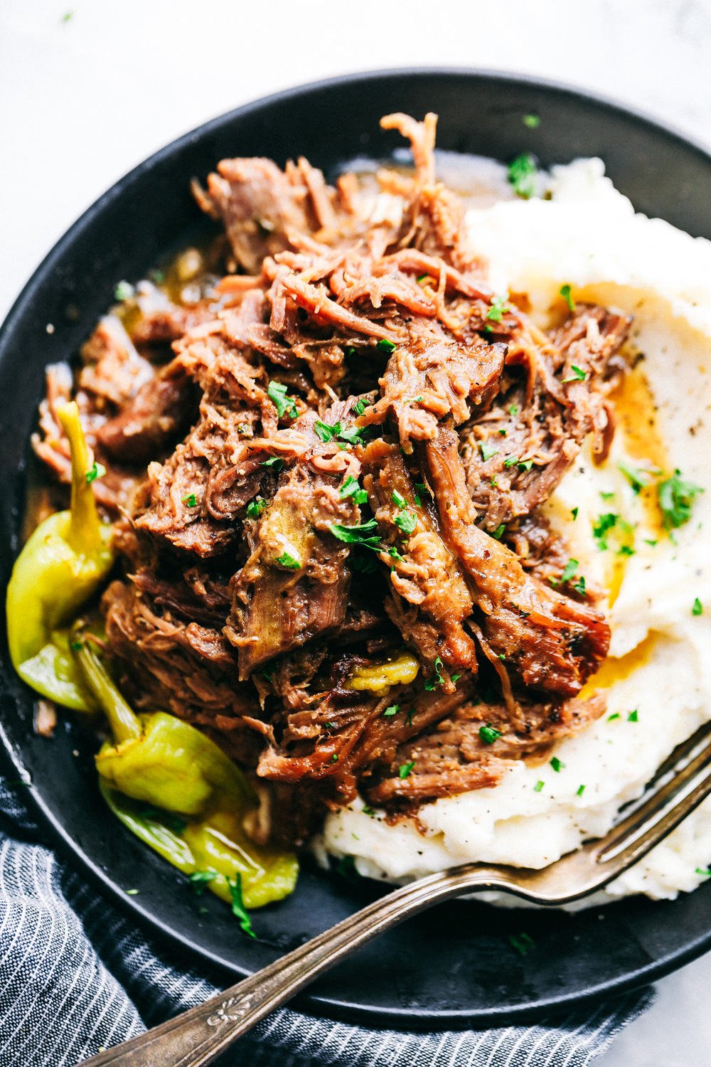 Pork roast on a plate with mashed potatoes.