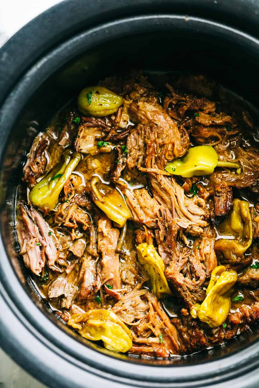 Slow Cooker Mississippi Pork Roast is a savory, sweet and spicy pork roast that is tender to the touch and falls apart with ease. It takes minutes to prepare and can be paired with a variety of sides. Your family will fall in love with this incredibly flavorful, melt in your mouth pork roast! Finished pork roast in crock pot.