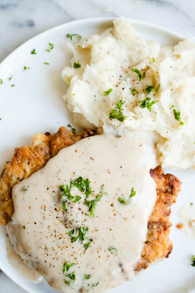 Areal view of finished chicken fried steak with gravy and mashed potatoes.