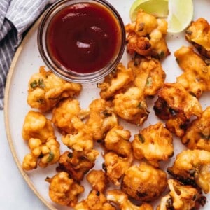 Cauliflower fritters served on a plate with ketchup