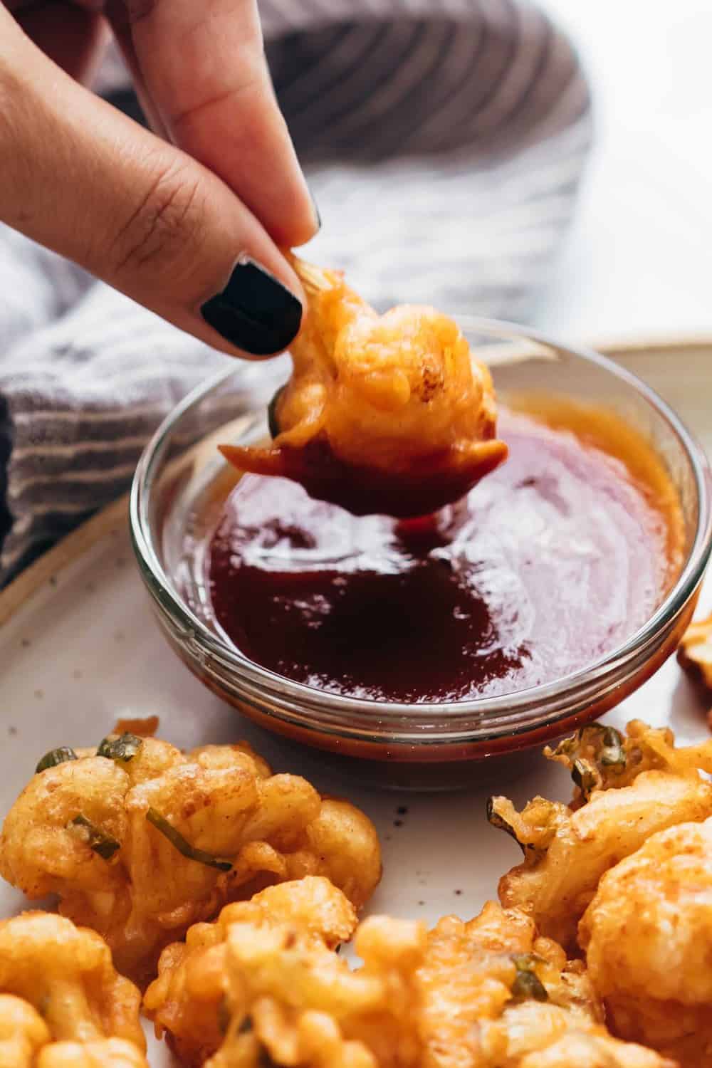 Cauliflower Fritters dipped into ketchup