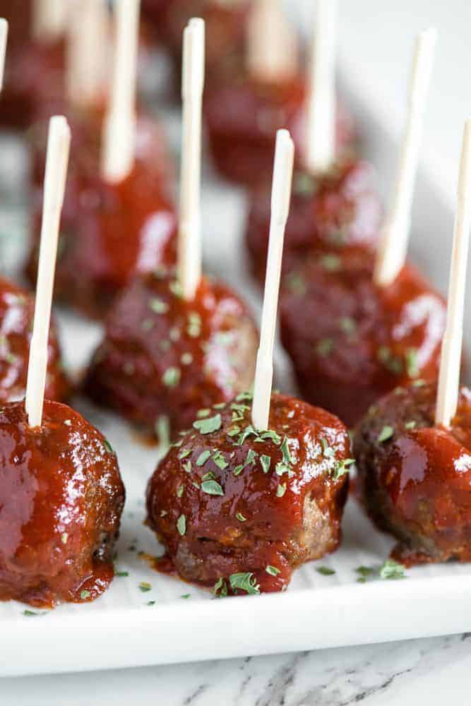 Meatloaf meatballs with toothpicks in them in rows.