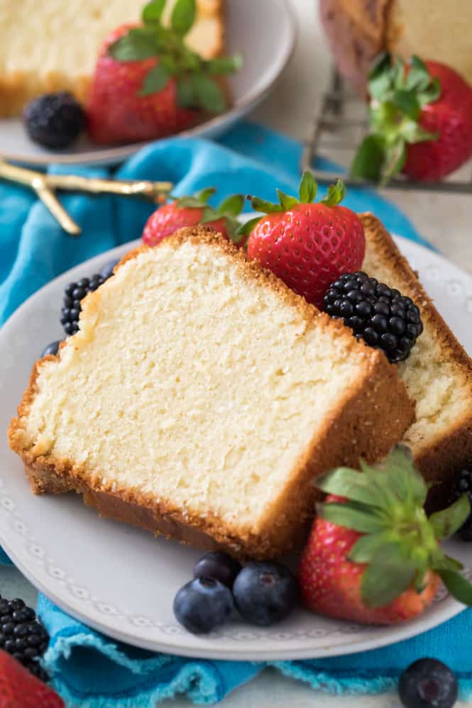 Slices of cream cheese pound cake on white plate with berries