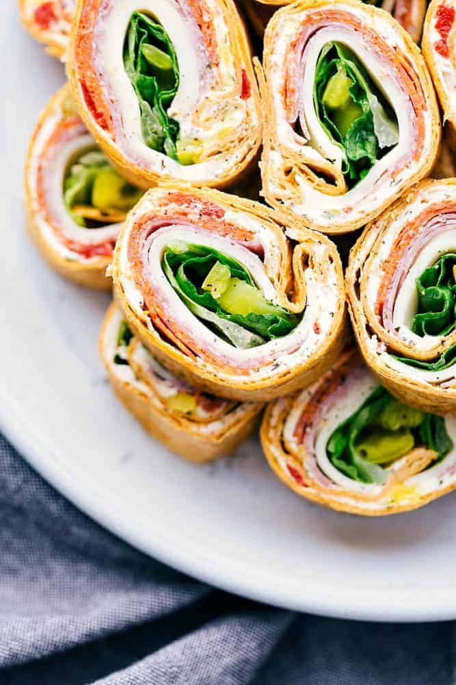 Italian pinwheels stacked on a white plate.