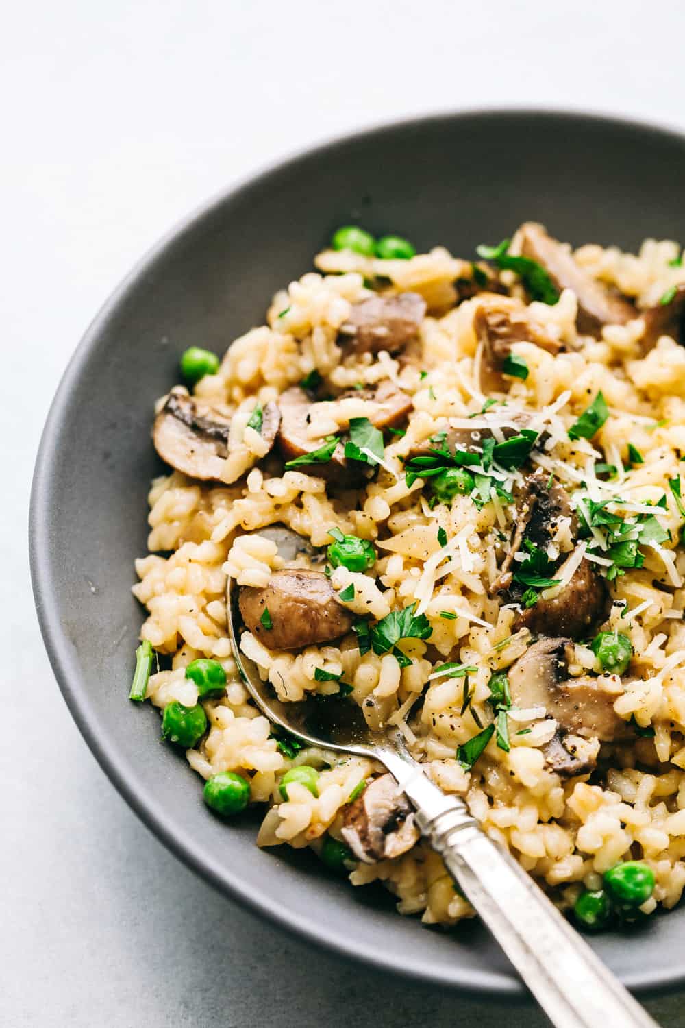 A plate of mushroom risotto with a spoon scooping some out.