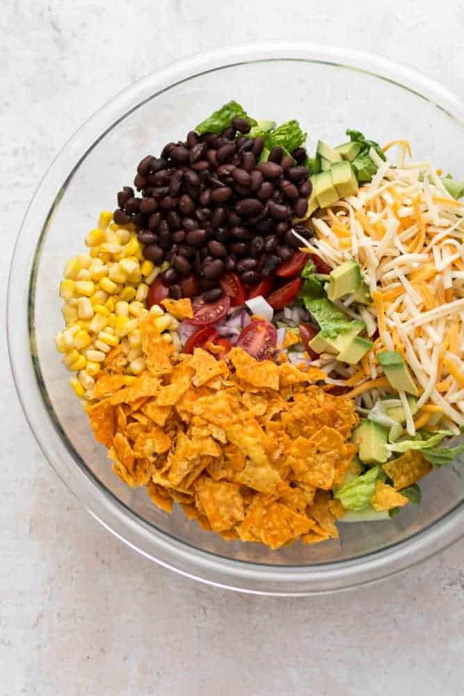 beef taco salad ingredients in a clear bowl.