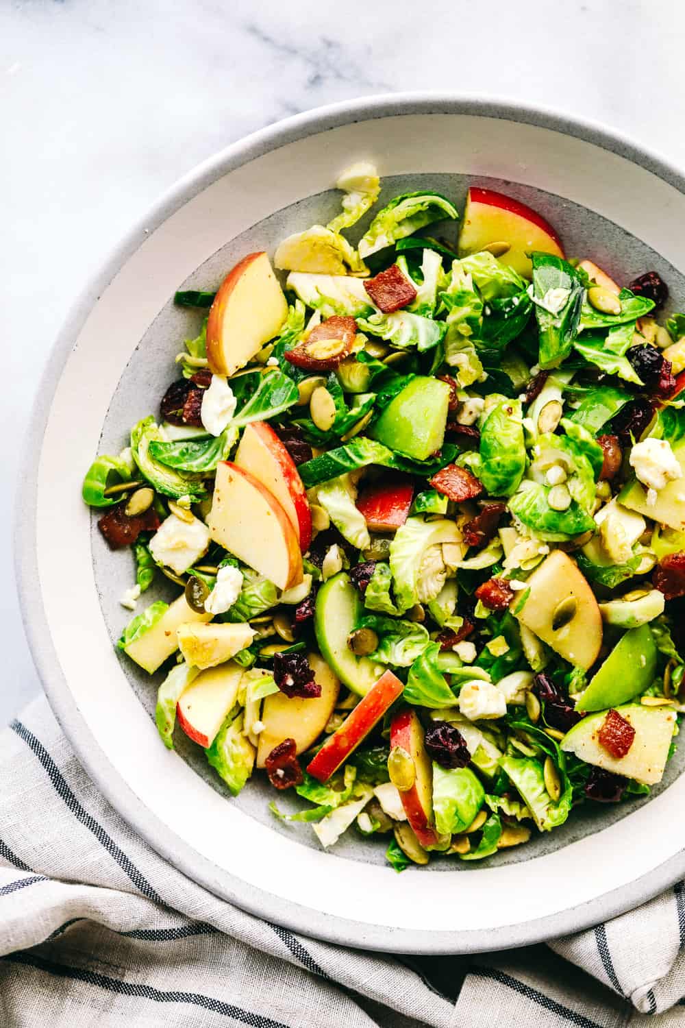apple bacon Brussels sprouts salad in a bowl. 