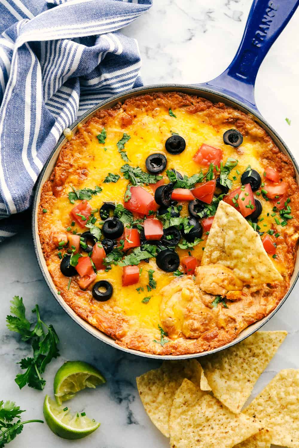 Bean dip in a blue cast iron pan with French fries.