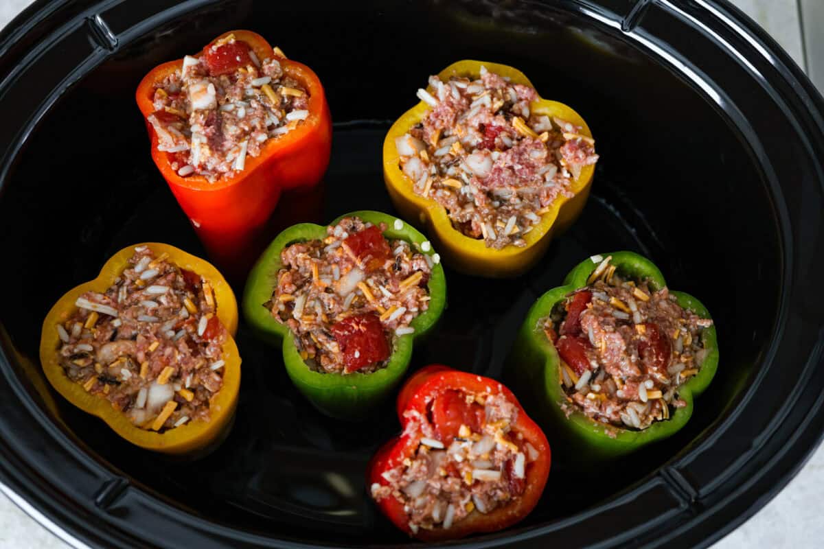 Overhead shot of stuffed bell peppers in slow cooker. 