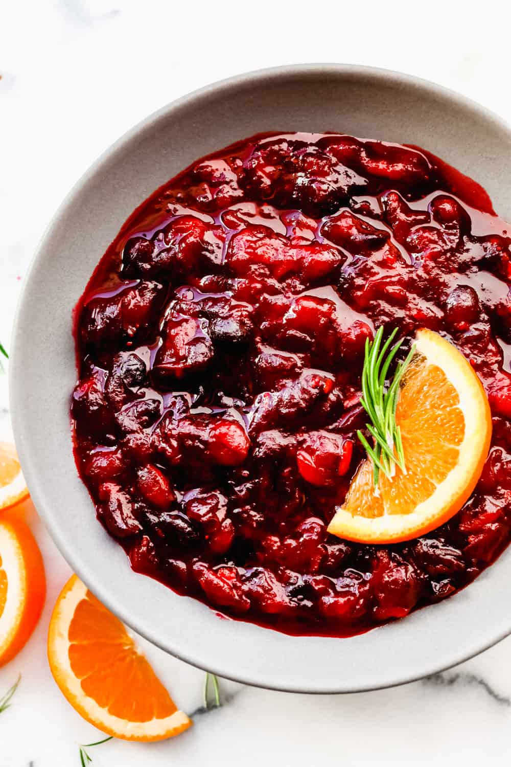 Cranberry sauce in a bowl with an orange slice. 