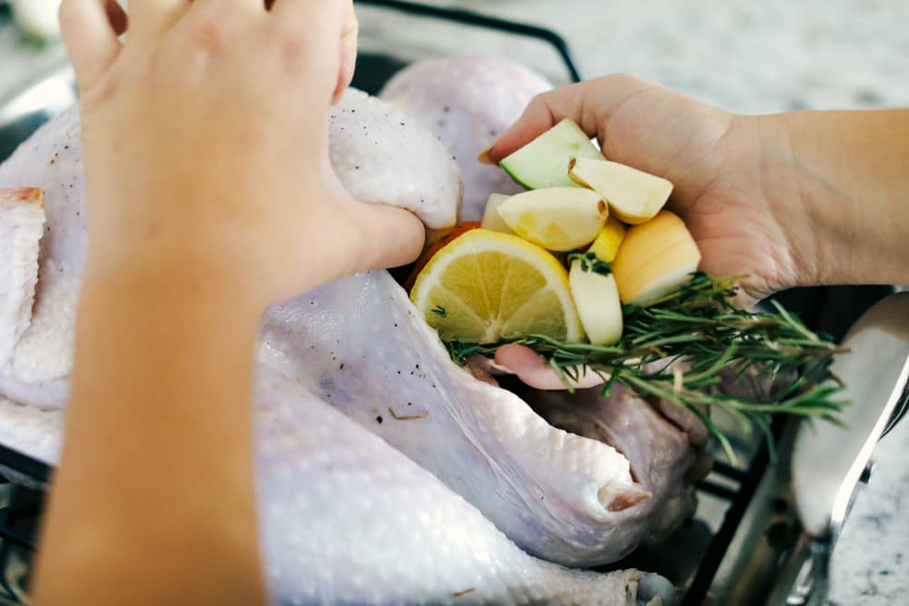 Turkey being prepared with lemon, apple and garlic herbs