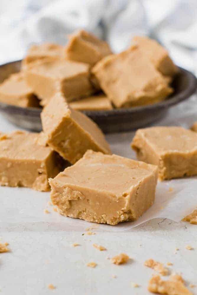 pieces of peanut butter fudge on surface and in tin