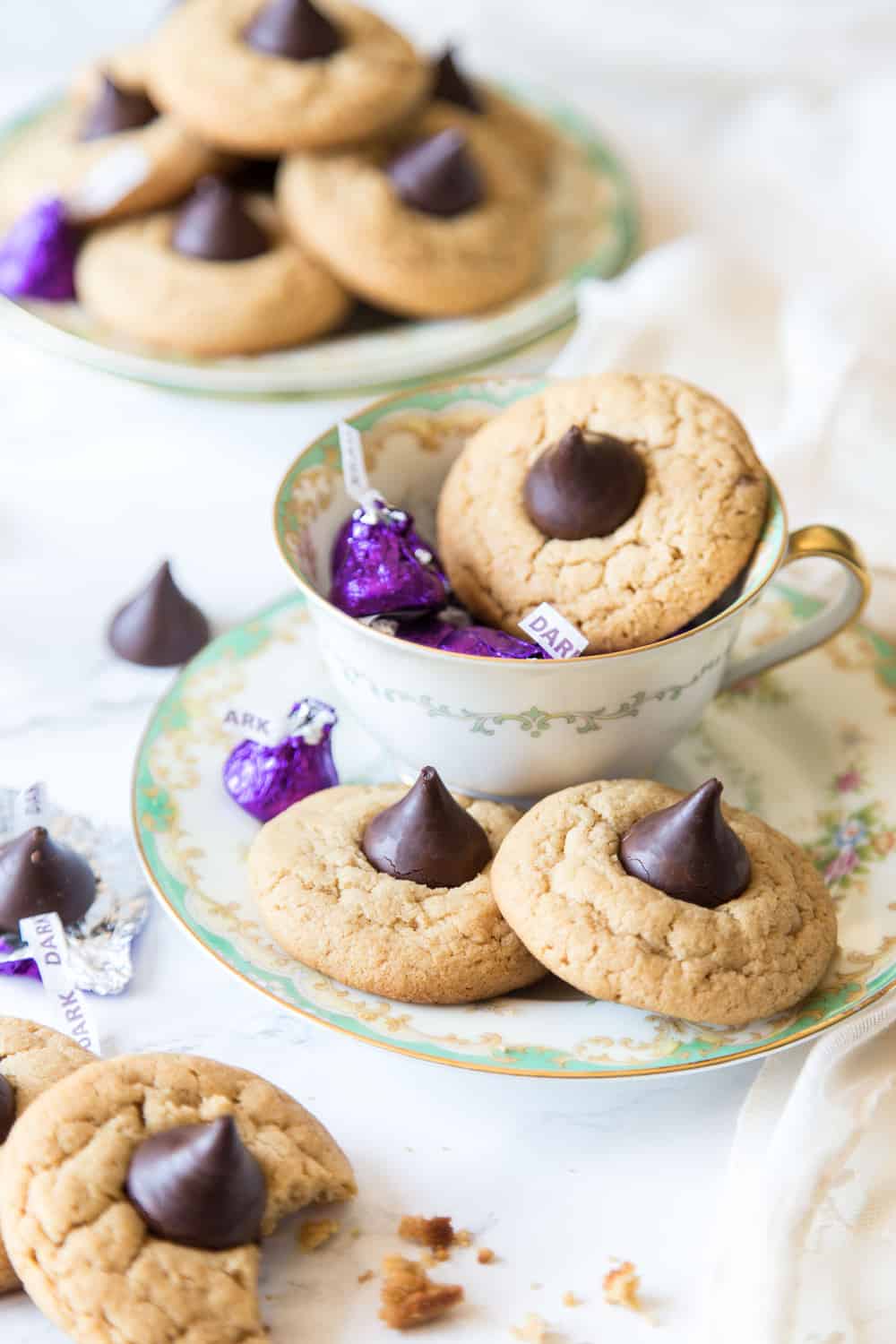 Peanut butter blossom cookies on plates and in tea cup