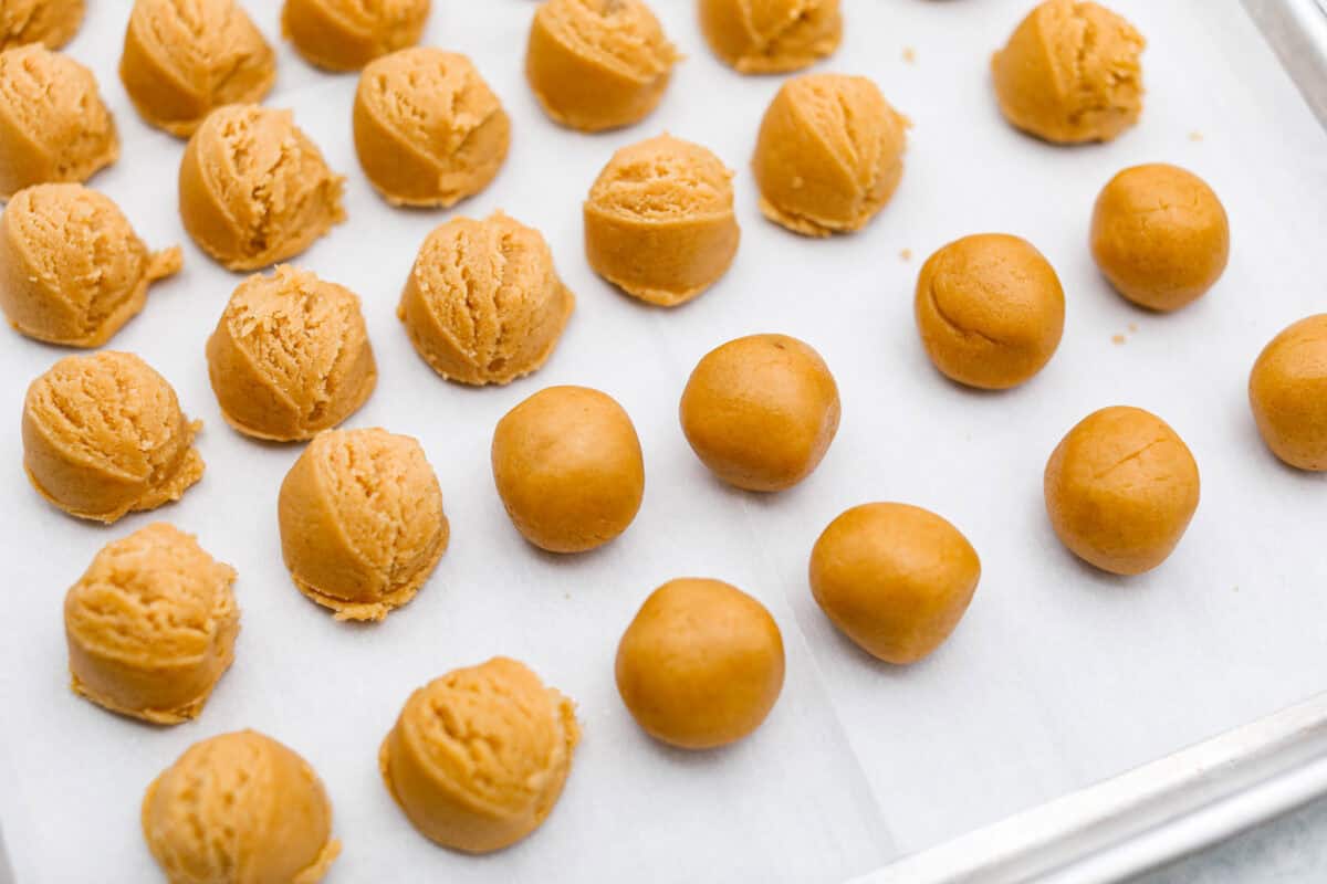 Overhead shot of cookie dough scooped into balls on a baking sheet. 