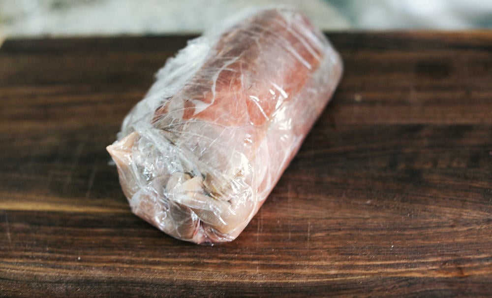 Beef Wellington tightly wrapped in a plastic wrap 