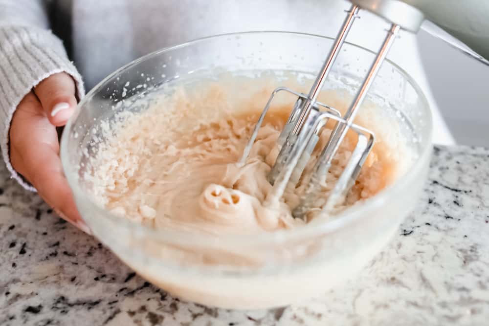 A hand mixer whipping the maple plant butter
