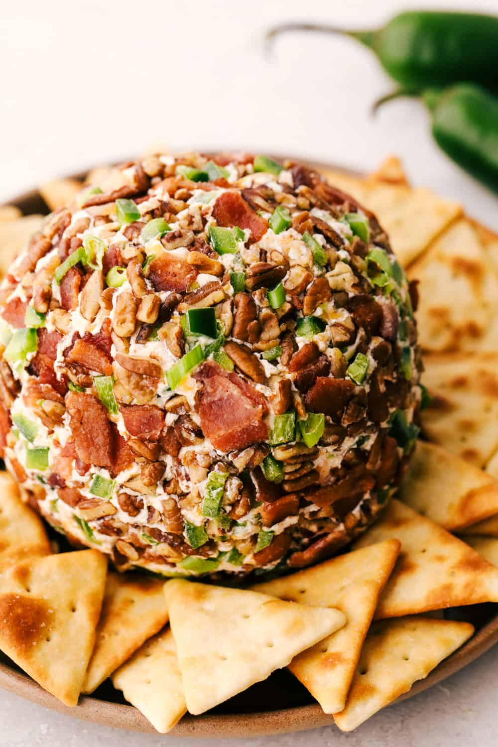 Bacon infused jalapeno cheese ball plated with crackers.
