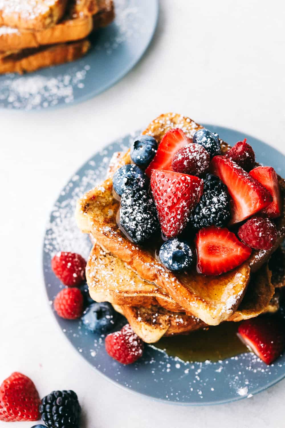 French toast sliced with berries and powdered sugar.
