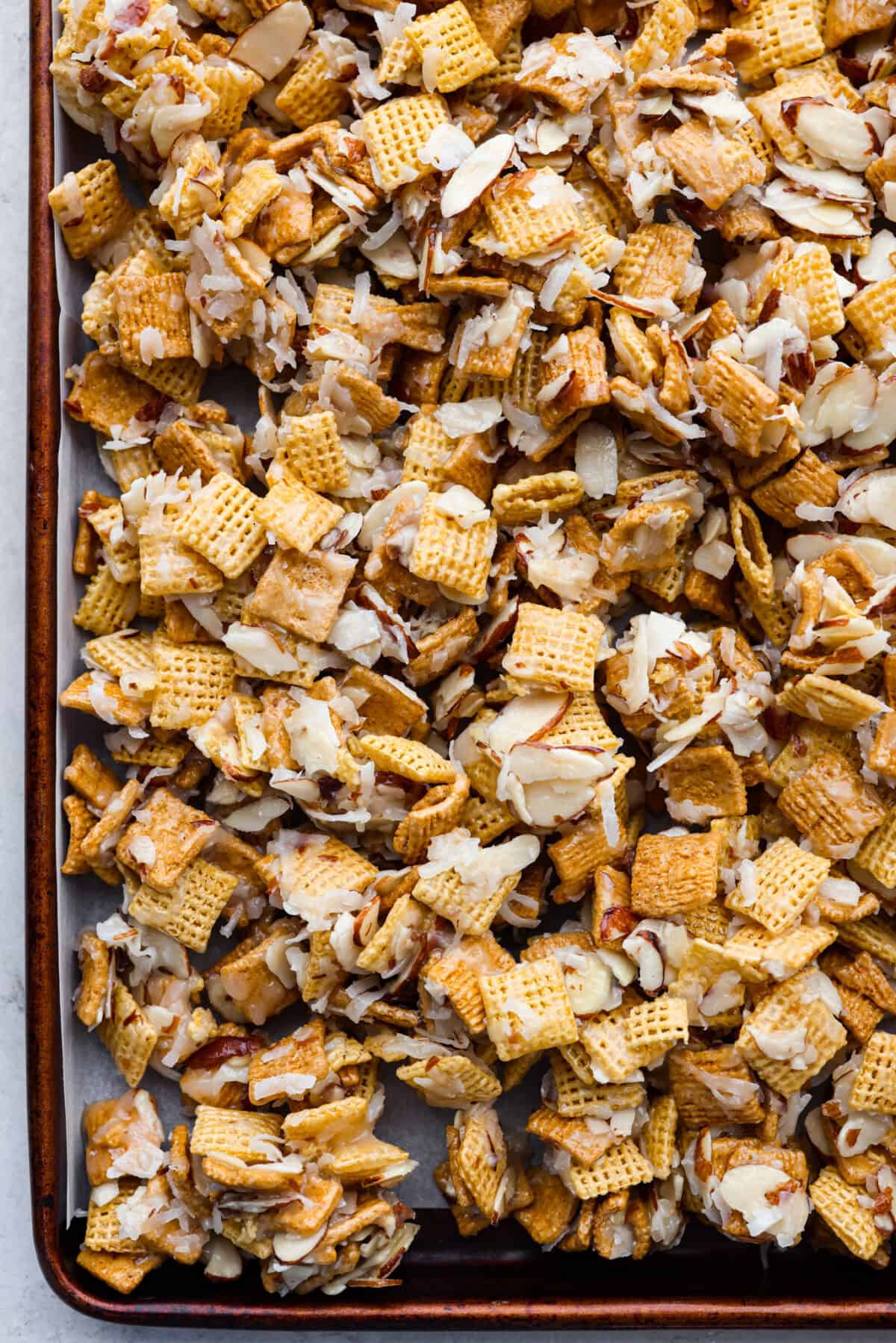 Overhead shot of ooey gooey Chex mix on a baking sheet. 