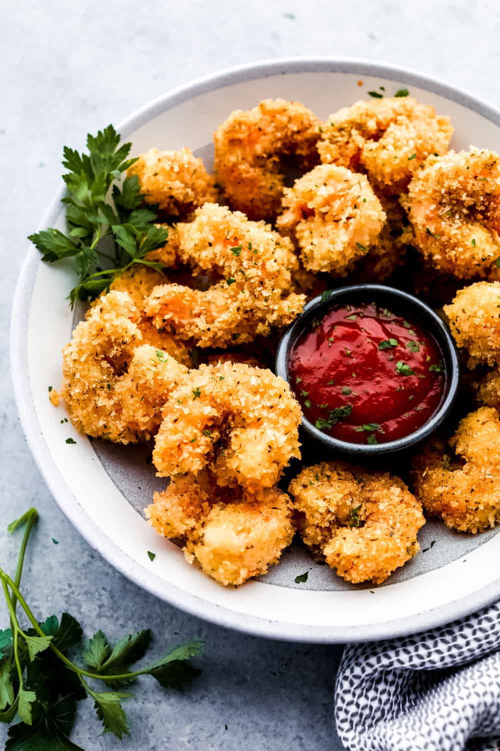 Camarones cajún palomitas de maíz en un plato con salsa de cóctel 