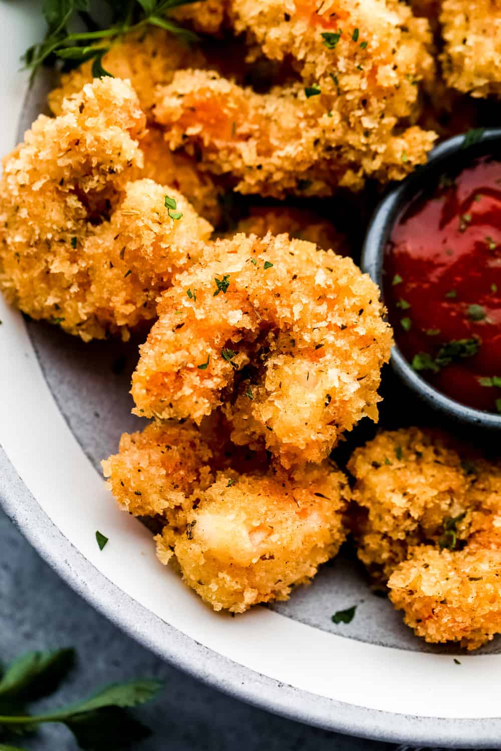 Cajún palomitas de maíz camarones de cerca en un plato con salsa de cóctel. 