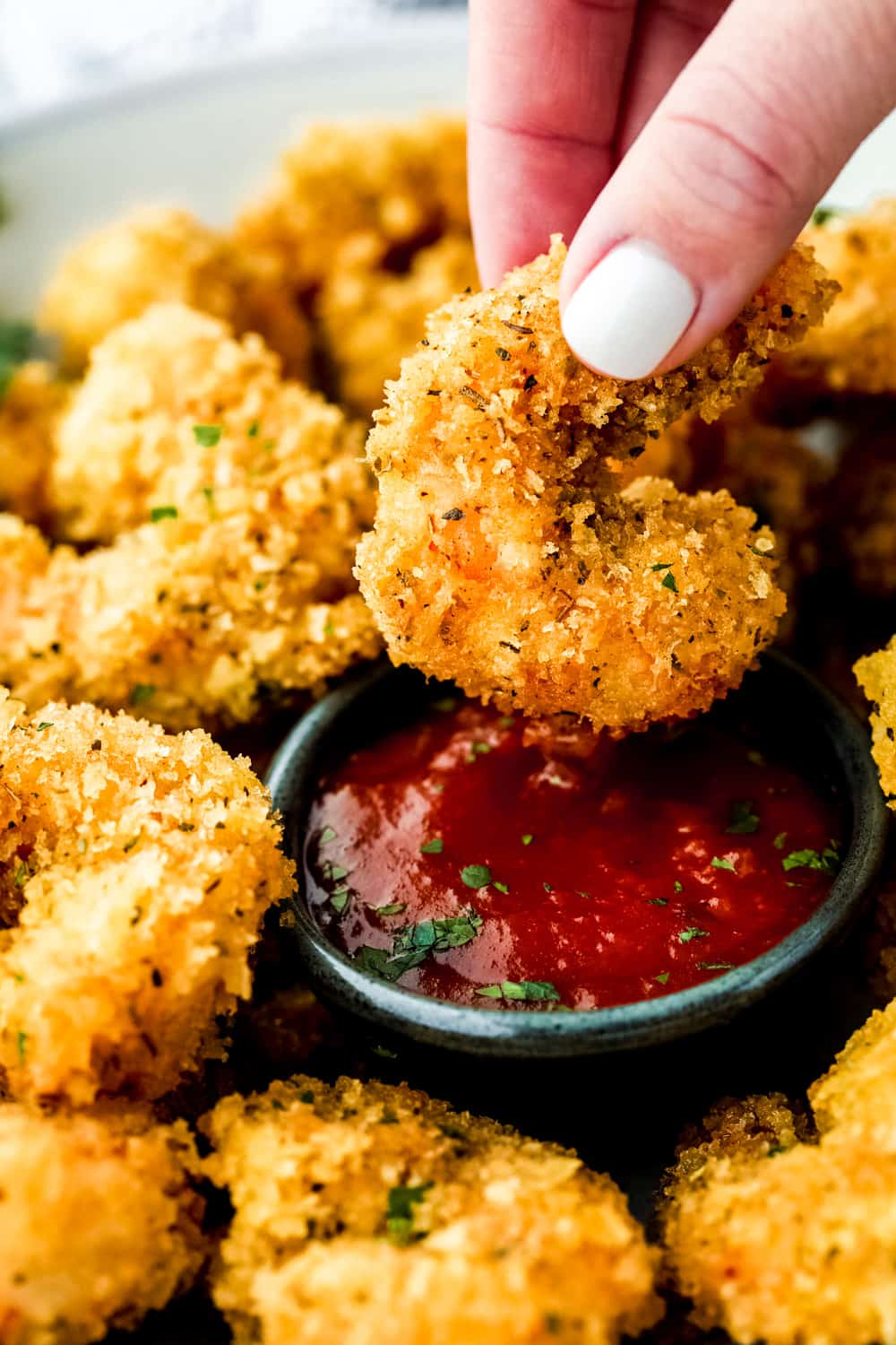 Camarones cajún con palomitas de maíz bañados en salsa de cóctel. 