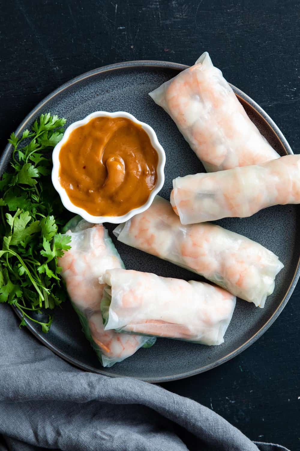Shrimp spring rolls on a plate with dipping sauce. 