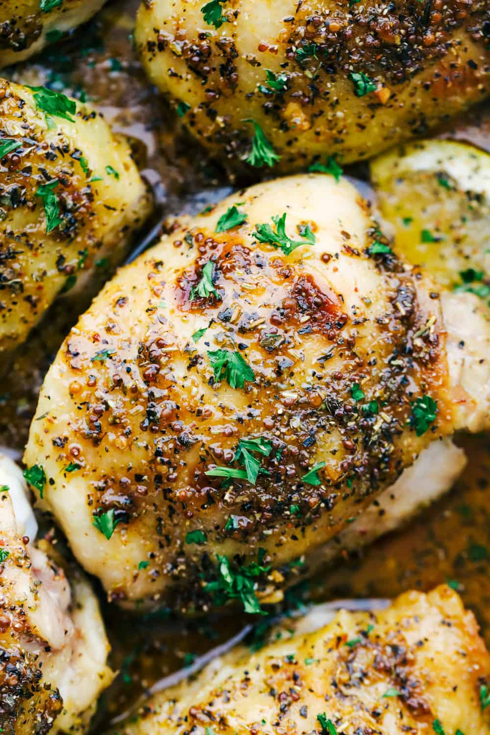 Baked chicken thighs unclose photo with a lemon slice and garnished with parsley. 