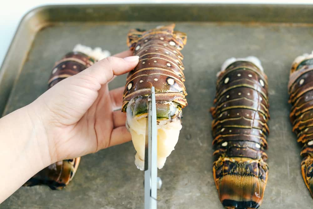 Butterflying the lobster tails down the middle of their shell.
