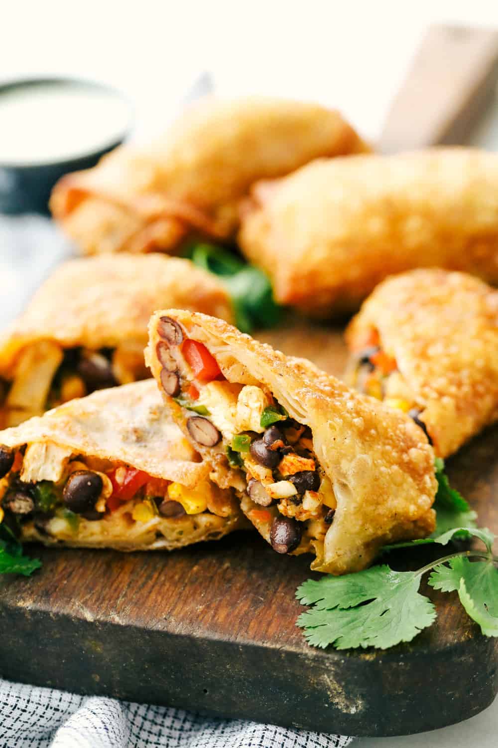 Southwest chicken egg rolls cut in half on the cutting board.