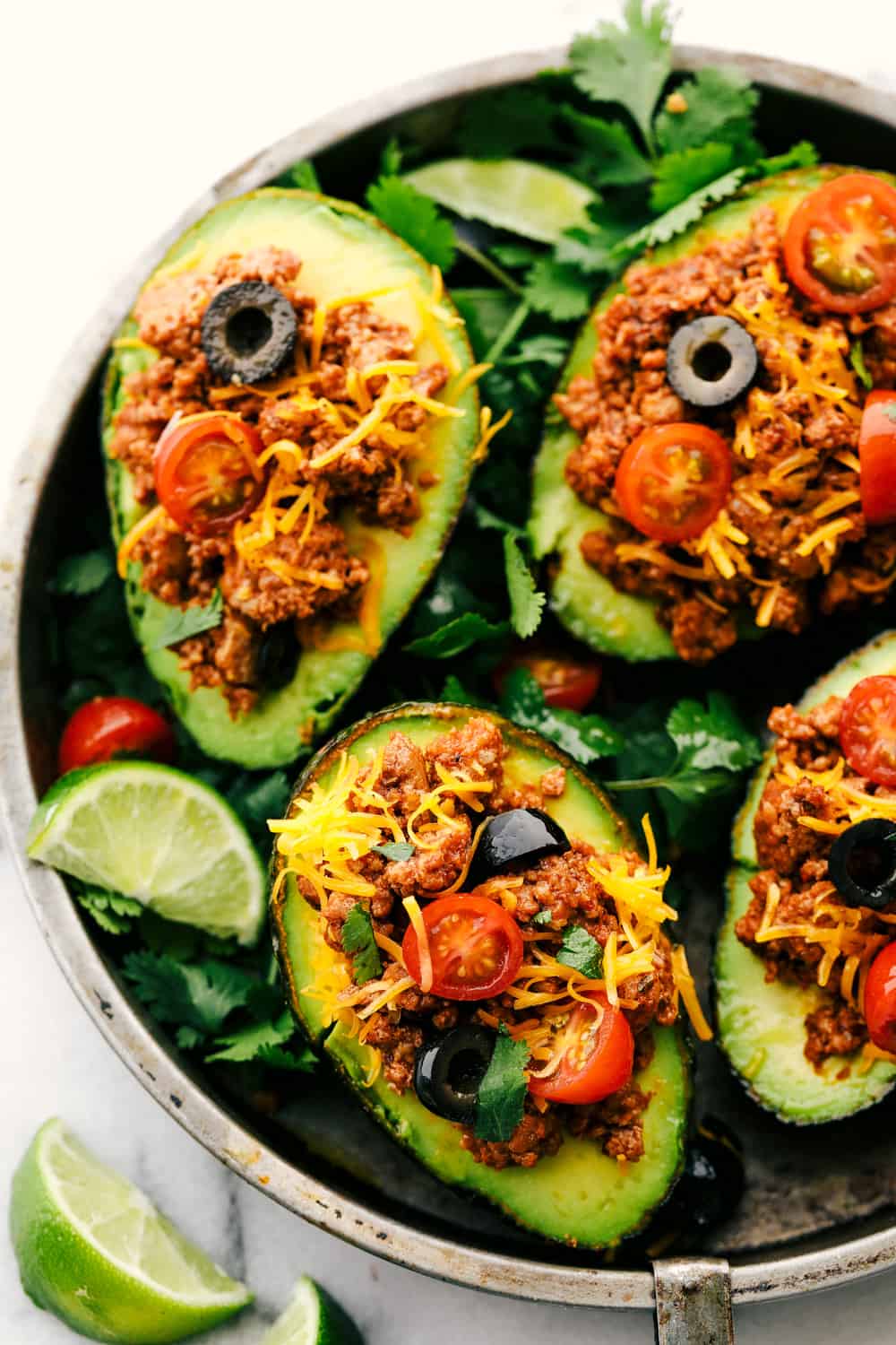 Turkey Taco Stuffed Avocados in a pan with lime wedges.