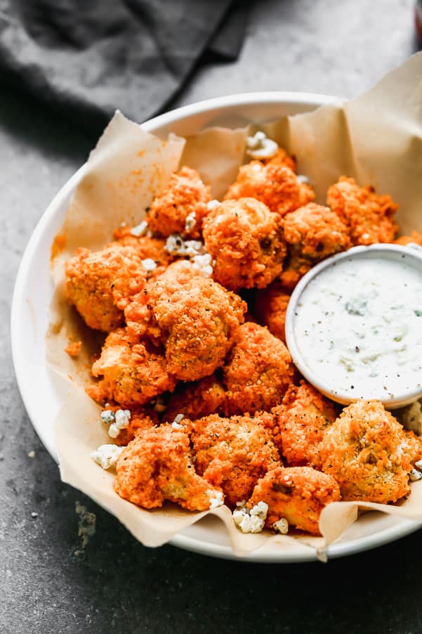 Buffalo cauliflower baked and in a bowl with ranch dipping sauce 