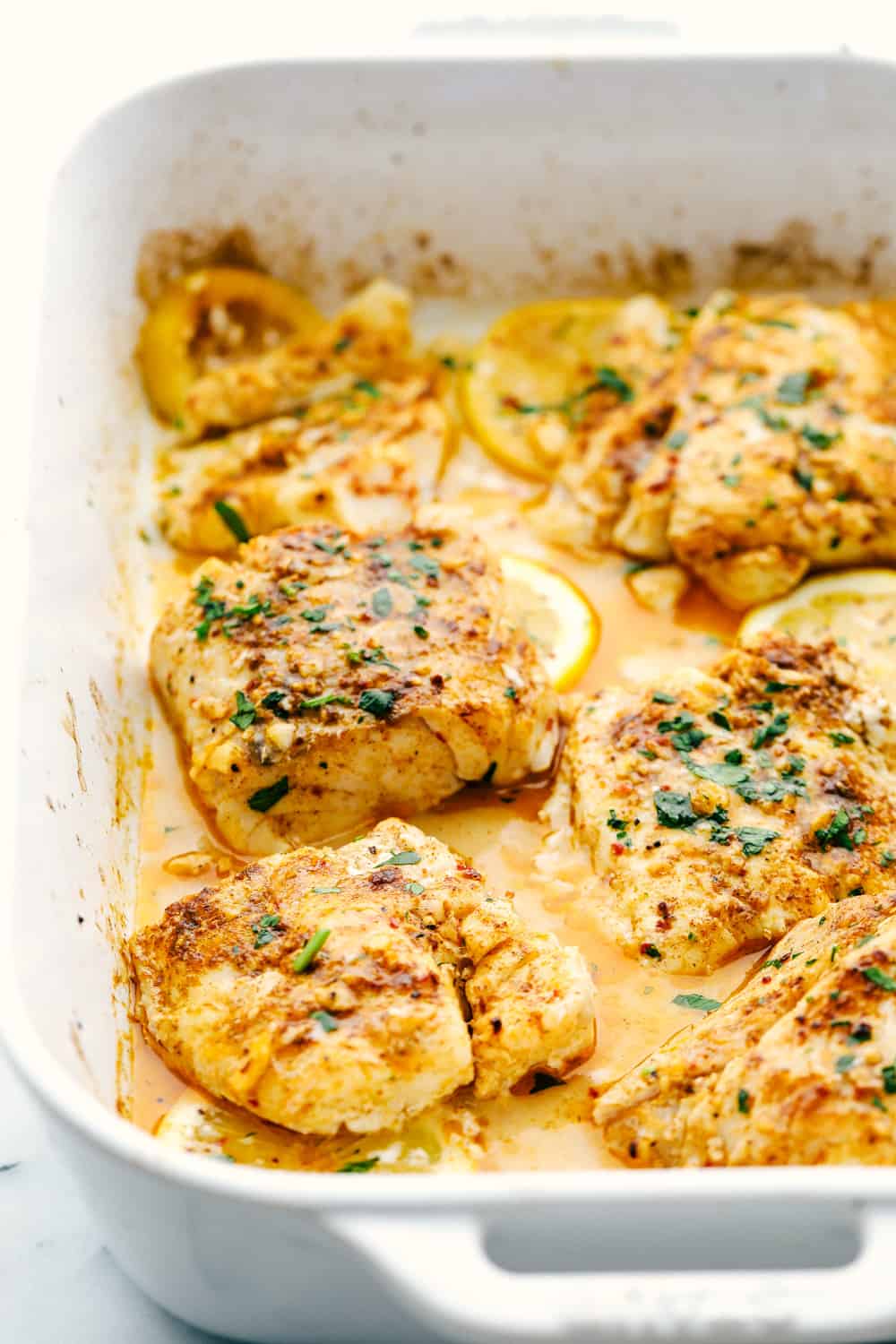 Cod filets being baked in cajun garlic butter sauce. 