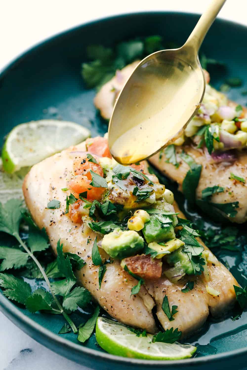 Mahi Mahi served on a plate garnished with avocado salsa and drizzled with brown butter sauce.