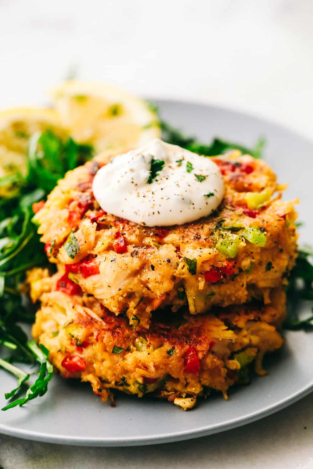 Dos croquetas de pollo apiladas una encima de la otra con una cucharada de salsa. 