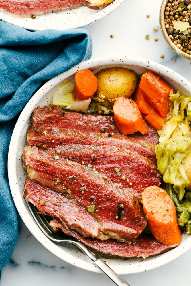 Corned beef in a bowl with carrots, potatoes and cabbage. 