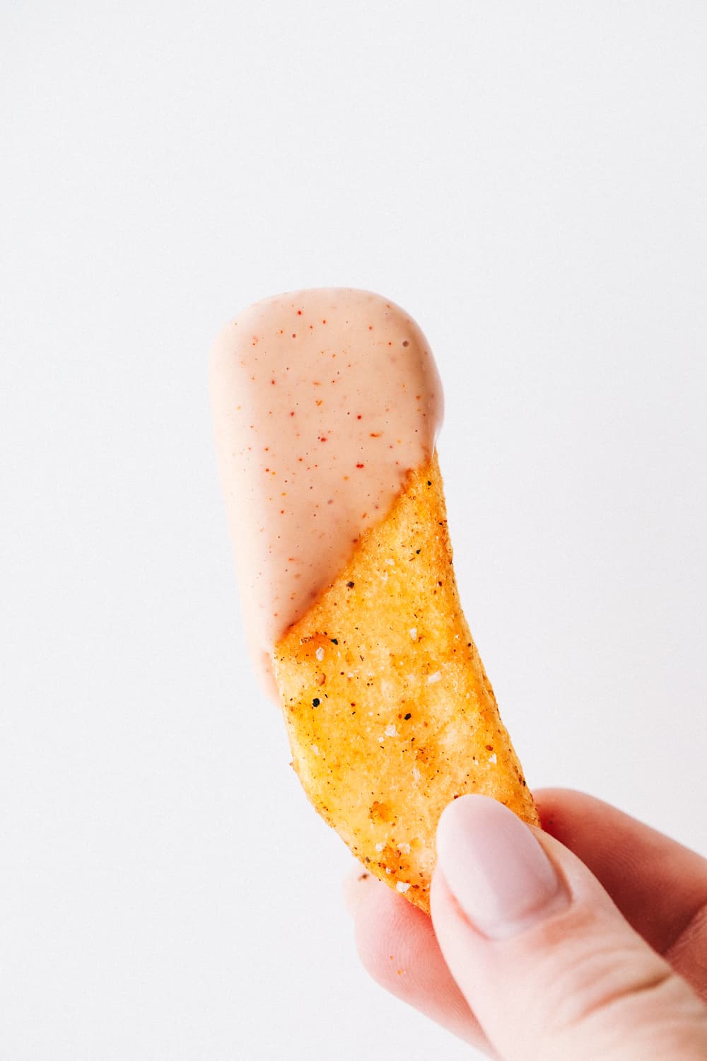 A fry dipped in Fry sauce held up. 