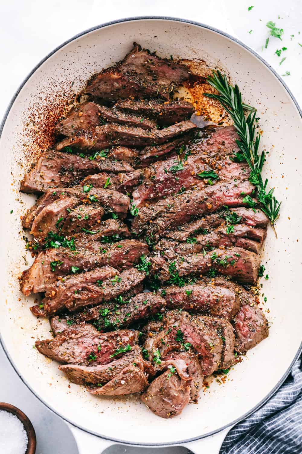 London Broil cut in slices plated on a white plate. 