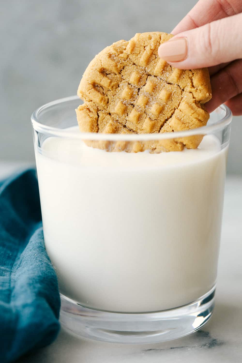 3 Ingredient peanut butter cookie dipped in a cold glass of milk. 
