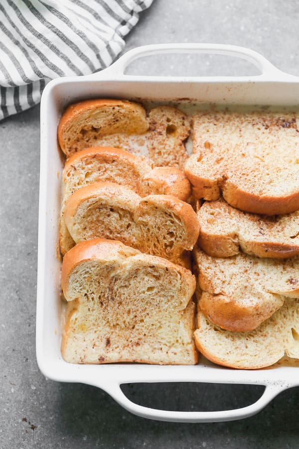 Thick toast layered together in a white baking pan. 