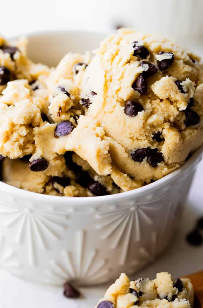 Edible chocolate chip cookie dough in a white glass bowl. 