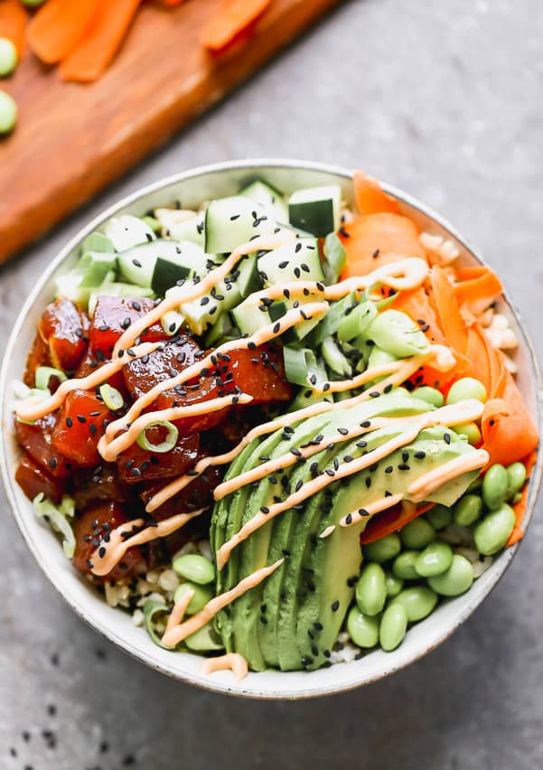 Poke bowl with ahi tuna, cucumbers, avocado and carrots all in a bowl. 