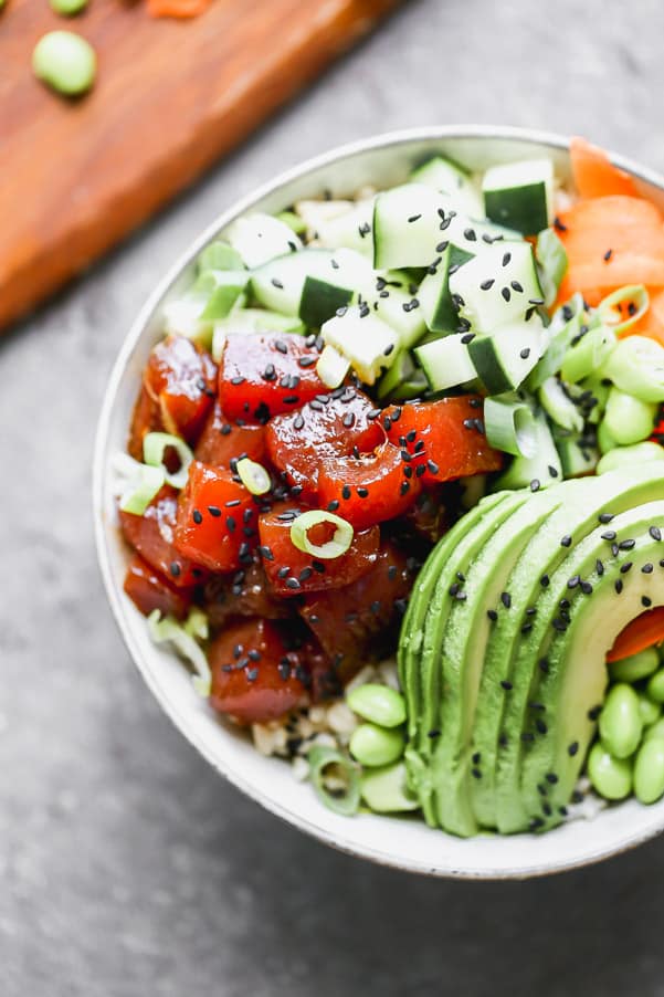 A complete poke bowl with ahi tuna, zucchini, avocado, edamame and sliced carrots. 