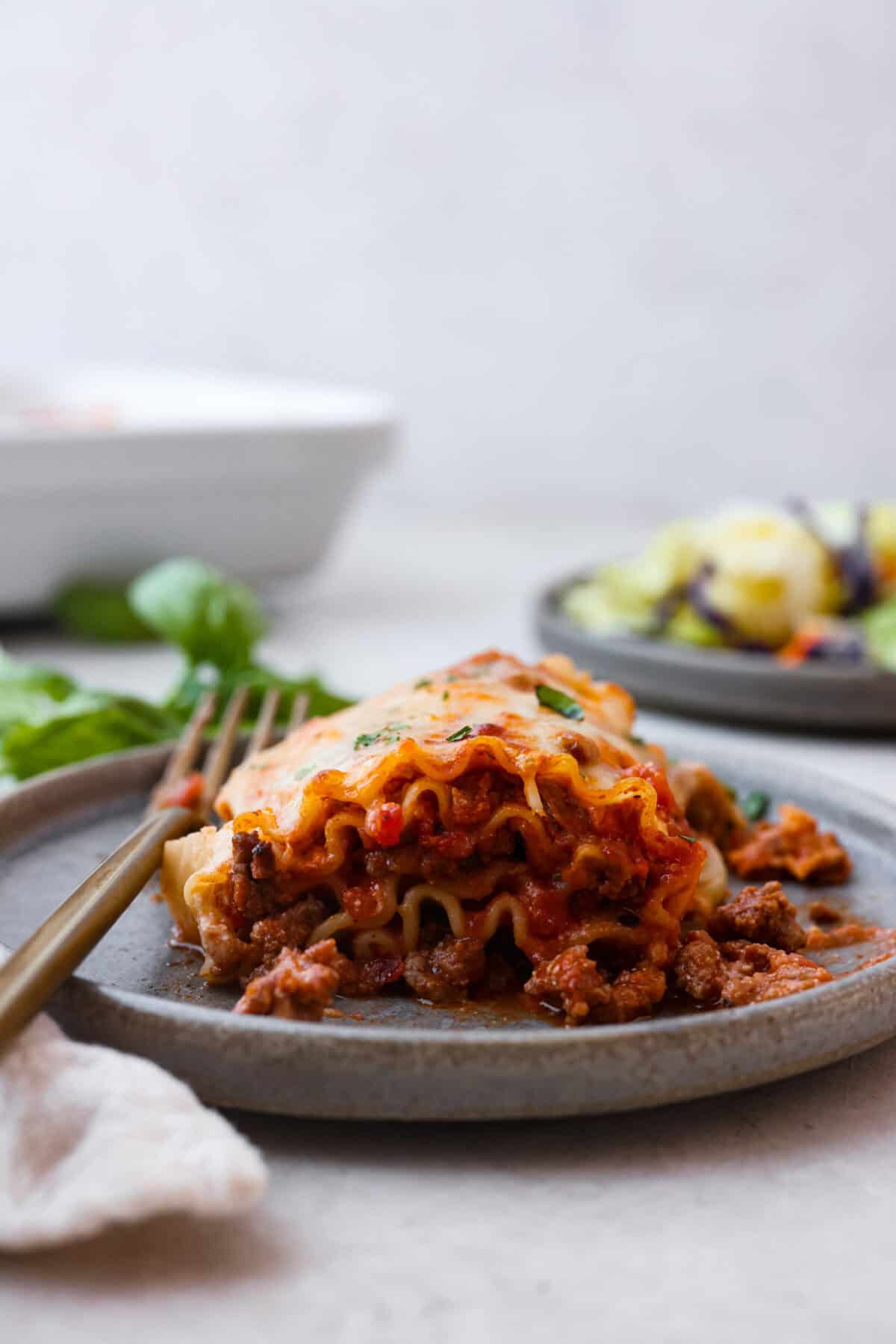 Side shot of plated lasagna roll up. 