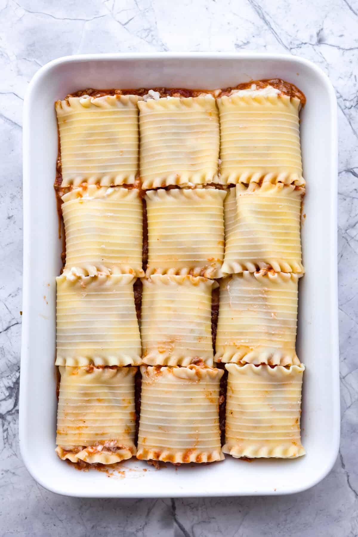 Overhead shot of lasagna roll ups in baking dish. 