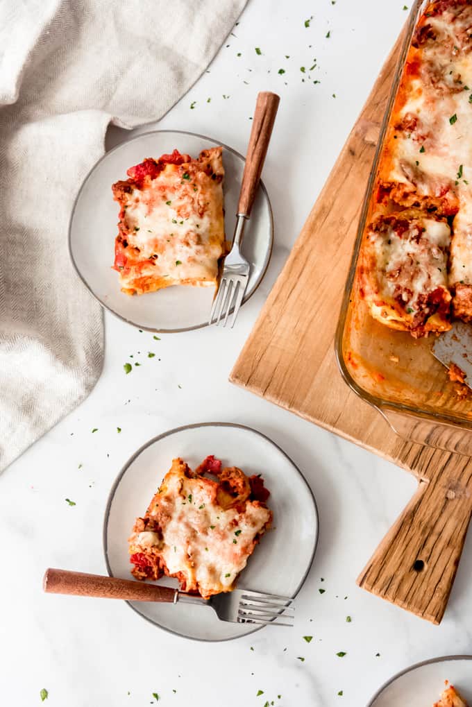 An image of two servings of meaty lasagna roll ups on small plates.