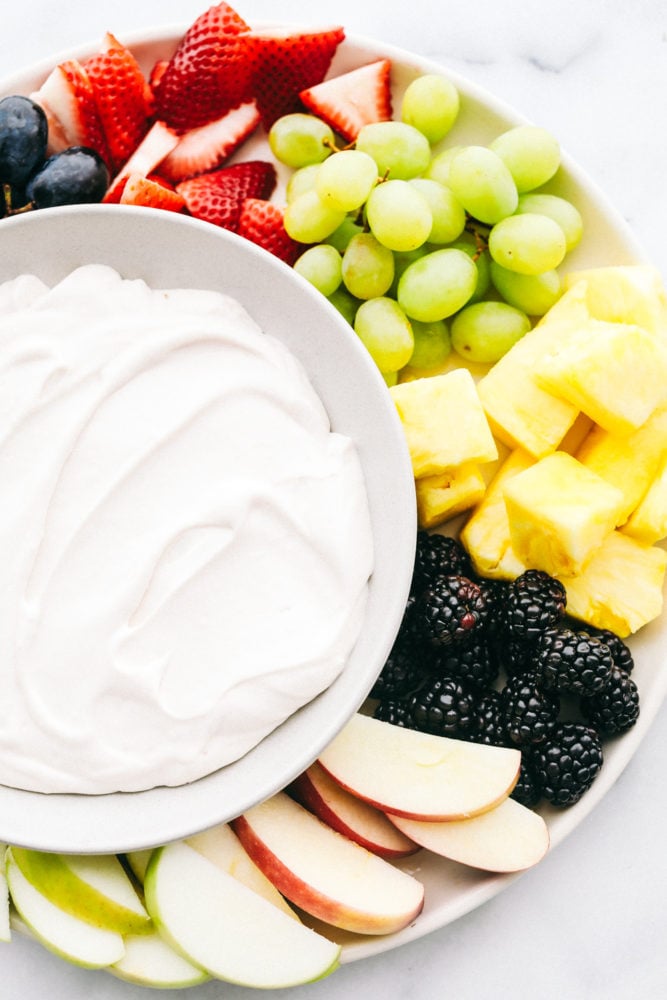 Fruta fresca preparada con un plato de salsa de fruta de queso crema de malvavisco. 