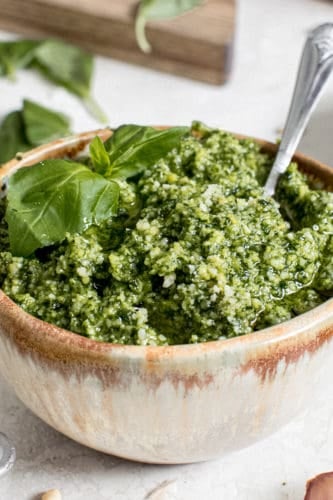 best basil pesto in pottery bowl with silver serving spoon