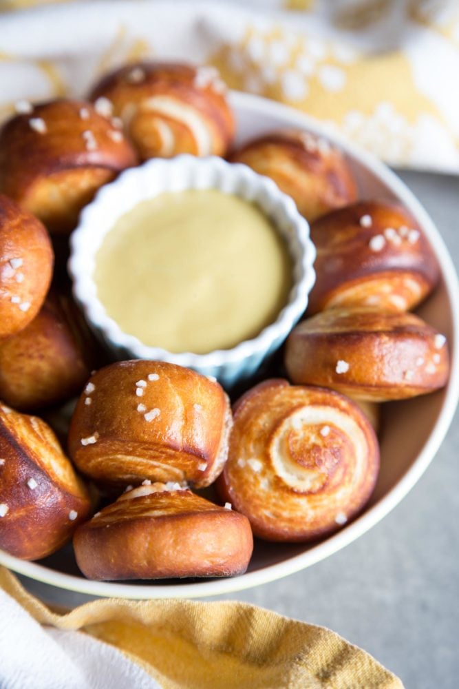 Pretzel muerde en un tazón con una taza de mostaza