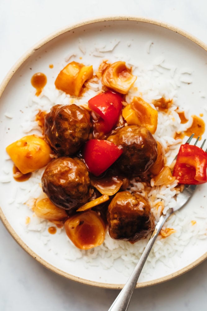 Albóndigas agridulces servidas sobre arroz en un plato